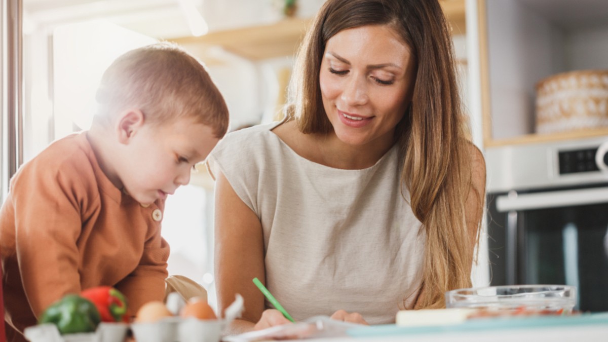 Young boy speaking with a parent during a learning activity at home