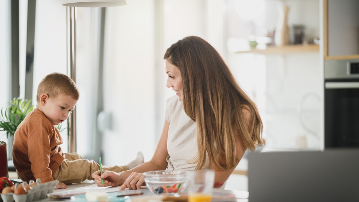 Child and parent at a table during an online English speaking lesson